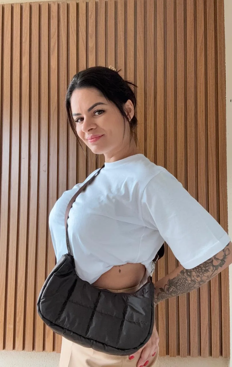 Deia usando uma bolsa artesanal preta Amor e Ponto
